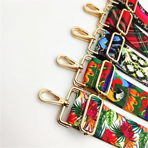 Close-up of patterned canvas bag straps with high-quality gold metal lobster clasps