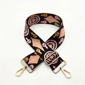 Close-up of ethnic geometric pattern woven bag strap with golden metal swivel hooks