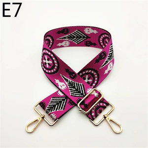 Detailed view of magenta ethnic geometric patterned shoulder strap with gold metal buckles