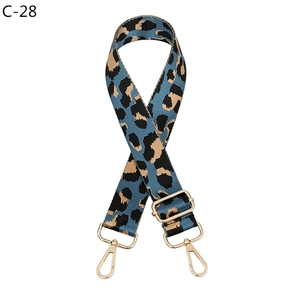 Close-up of leopard print shoulder strap with gold metal buckle and swivel hooks