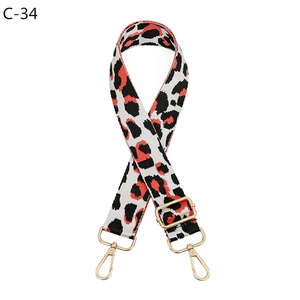 Detail of red and white leopard print bag strap with golden adjustable buckle