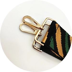 Close-up of tricolor striped canvas strap with golden alloy swivel spring hook clasp