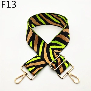 Macro detail of wide striped canvas strap with gold metal hooks and zebra pattern