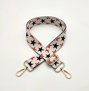 Macro detail of star pattern woven strap with gold metal buckles and swivel hooks