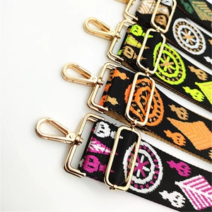 Close-up of ethnic embroidered bag straps with vintage geometric patterns and gold hooks