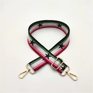 Close-up of adjustable bag strap with star patterns and golden metal rotating hooks
