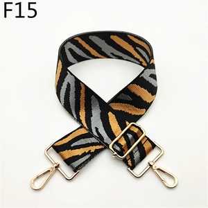 Close-up of zebra pattern canvas bag strap with golden metal carabiner hooks