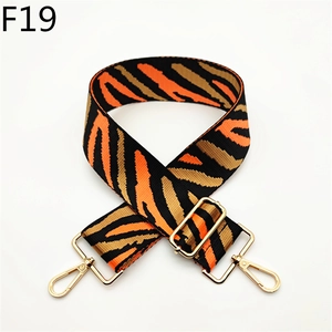 Detail of tiger pattern canvas shoulder strap with gold metal hooks and adjustable buckle