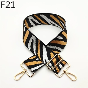 Detail of adjustable zebra stripe canvas shoulder strap with gold metal lobster clasps