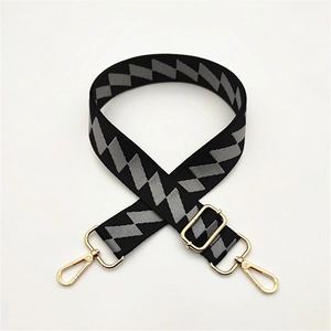 Close-up of adjustable bag strap with black and grey geometric pattern and gold hardware