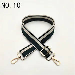 Close-up of adjustable striped bag strap with green and white pattern and gold buckles