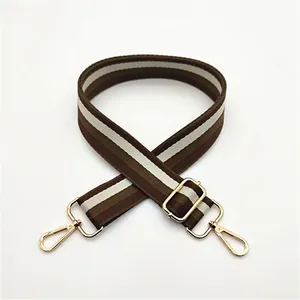 Detail of adjustable No. 12 brown and white striped bag strap with gold metal hooks