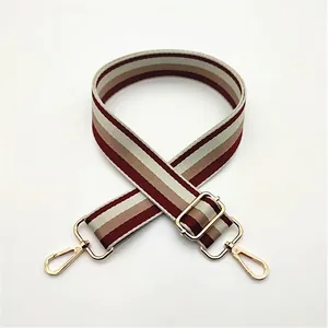 Close-up of adjustable striped strap with high-quality gold-tone metal buckles