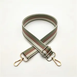 Detail of adjustable woven striped bag strap with gold metal buckles and lobster clasps