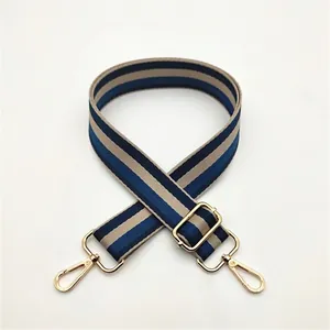 Close-up of adjustable striped bag strap with gold alloy buckles and blue yellow webbing