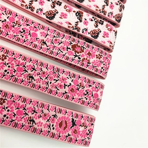 Detailed macro view of wide floral pattern shoulder straps for handbags with pink ethnic motifs