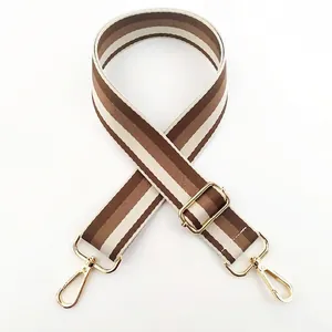 Macro detail of adjustable colorful striped bag strap with gold metal hooks and buckle