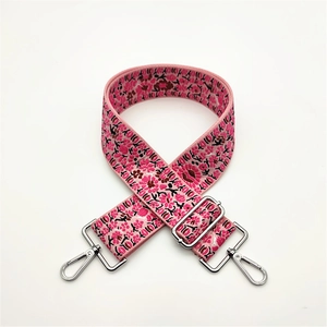 Close-up of pink floral pattern bag strap with silver metal swivel hooks and adjuster