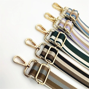 Detail view of colorful striped fabric shoulder straps with golden metal swivel hooks