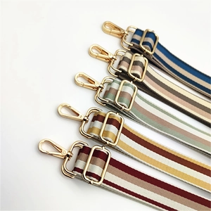 Detail of adjustable thick fabric shoulder straps with colorful stripes and gold metal hooks