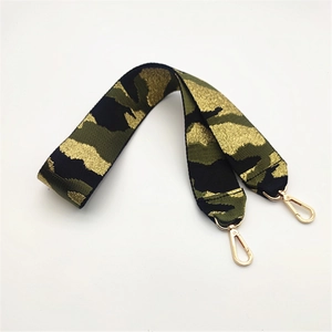 Detailaufnahme der breiten Camouflage-Taschengurt mit glänzenden goldenen Karabinerhaken