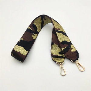 Nahaufnahme des breiten Camouflage-Taschenriemens mit goldenen Metallkarabinern auf Weiß