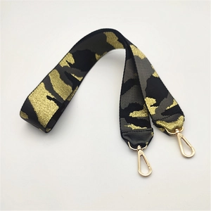 Nahaufnahme des breiten Camouflage-Taschenriemens mit goldenen Karabinerverschlüssen