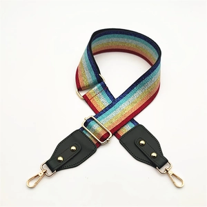 Close-up of rainbow striped wide bag strap with gold metal hooks and glitter thread