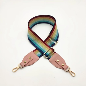 Detail of adjustable rainbow striped bag strap with gold metal hooks and pink leather ends