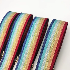 Detail of colorful metallic woven bag strap with shiny lurex stripes and gold buckle