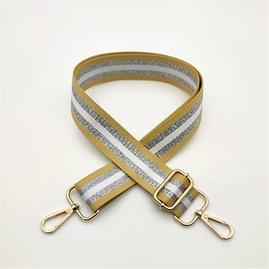 Detail of adjustable bag strap featuring gold and silver glitter stripes and metal clasps