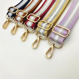 Detail of adjustable woven shoulder straps with metallic silver thread and gold metal buckles