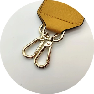 Close-up of yellow PU leather bag strap end with heavy-duty gold metal swivel clasps