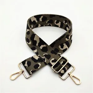 Detail of adjustable leopard print bag strap with polished gold-tone metal snap hooks