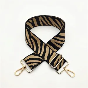 Adjustable woven handbag strap with classic zebra pattern and gold metal hardware