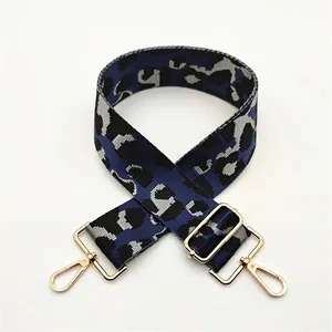 Detail of wide leopard print bag strap with blue jacquard and gold metal lobster clasps