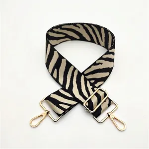 Close-up of zebra pattern wide strap with adjustable golden metal hardware for bags