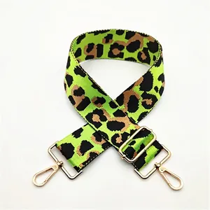 Detail of leopard print wide bag strap with neon green accents and gold hardware