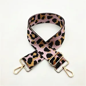 Close-up of pink leopard print wide strap with gold-tone metal hooks and adjustable buckle