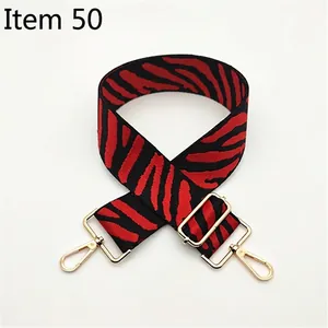 Detail view of adjustable zebra stripe bag strap with gold metal lobster clasps