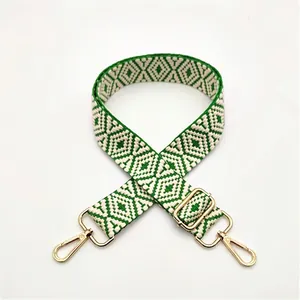 Detail of adjustable woven handbag strap in dark green and beige geometric pattern