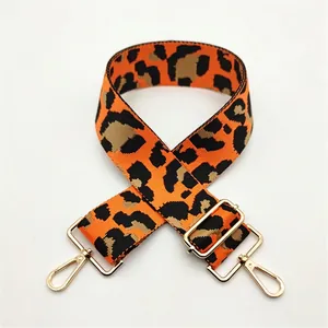 Macro shot of wide leopard print bag strap with durable woven fabric and gold lobster clasps