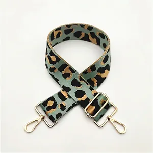Detail of adjustable leopard print bag strap with green base and golden metal hooks