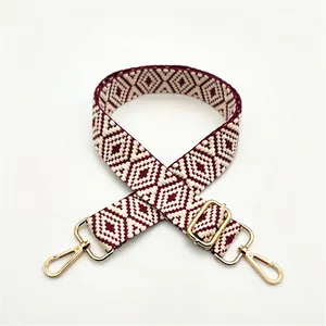 Close-up of geometric woven shoulder strap with gold metal buckle and burgundy diamond pattern
