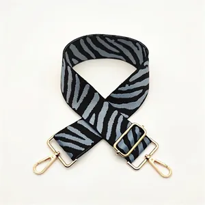 Detailed view of zebra pattern wide replacement strap with gold metal swivel hooks