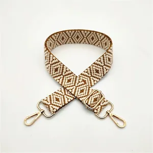 Detail view of woven diamond pattern bag strap in brown and beige with gold hardware