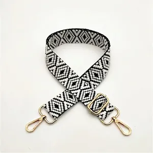 Close-up of black and white geometric woven replacement shoulder strap with gold buckles
