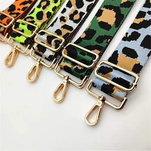 Detail view of five leopard print bag straps with golden metal hooks and adjustable buckles