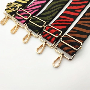 Close-up of adjustable zebra pattern bag straps with premium gold metal swivel hooks
