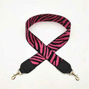 Close-up of zebra pattern handbag strap with black leather ends and gold metal hooks